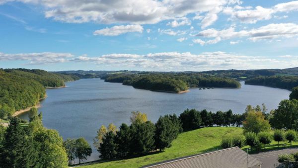 Journée ensoleillée sur le lac de Saint-Etienne-Cantalès de 600 hectares, vue depuis la salle polyvalente