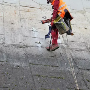 Photo du technicien entrain de fixer les étoiles sur la voute du barrage pour créer l'oeuvre Aster à Saint-Etienne-Cantalès