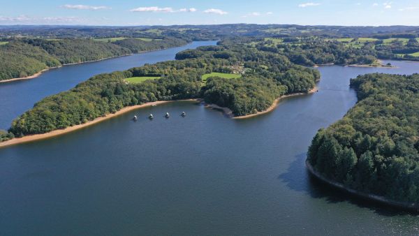 Vue d'ensemble du Lac de barrage de Saint-Etienne-Cantalès et ses chalets flottants dans le Cantal 